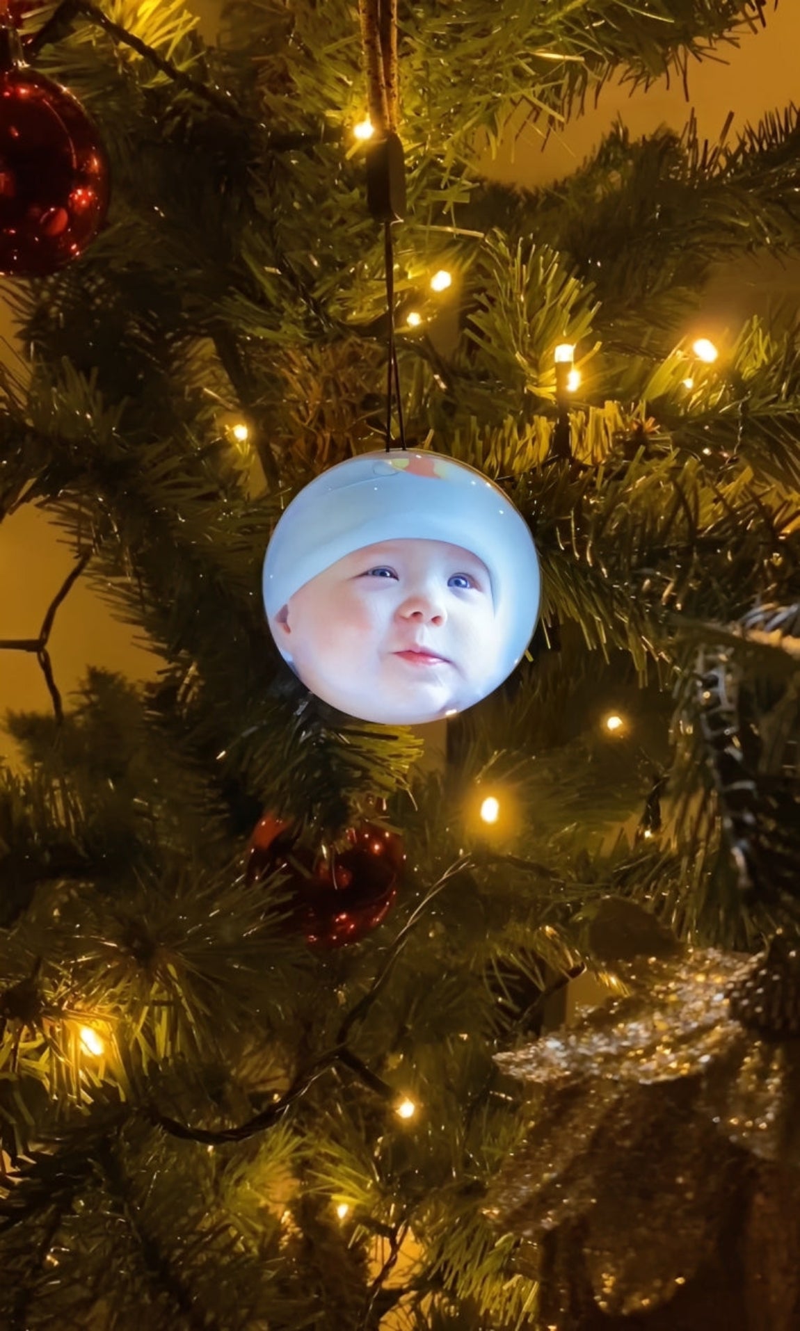 Christmas tree with ornaments, including a baby's face on one of them
